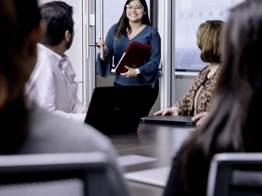 girl walking into a meeting at genesys works